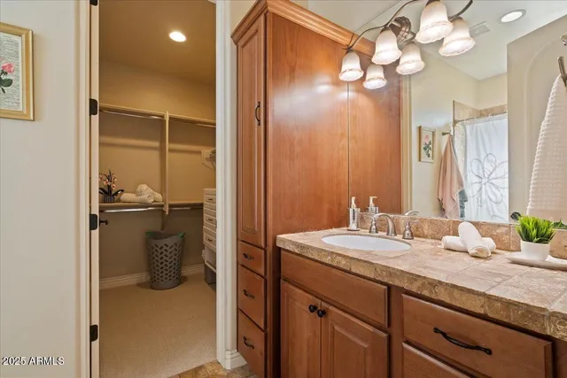 a bathroom with a granite countertop sink mirror and shower