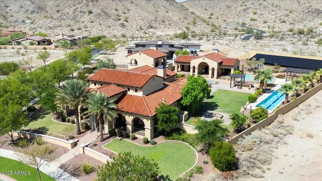 a view of a patio with a table and chairs under an umbrella with a barbeque grill and plants