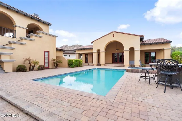 a view of a house with a yard and palm trees