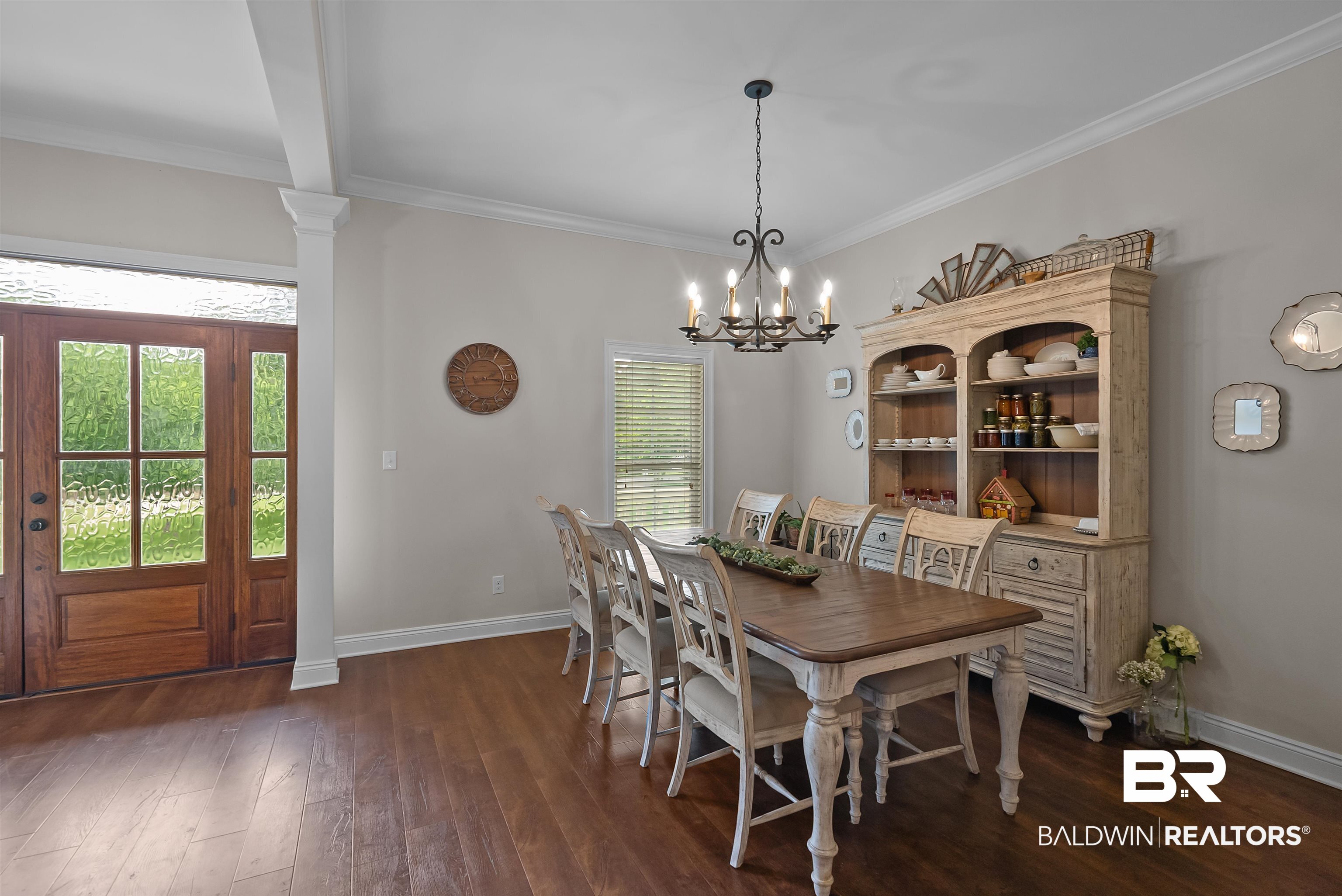 12070 Comalander Road Fairhope, AL 36532 - Photo 6 of 50 Dining area featuring wood-finish flooring, a decorative chandelier, and crown molding