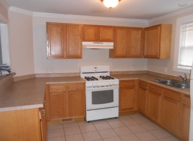 1014 Nicholson Street Joliet, IL 60435 - Photo 3 of 9 a kitchen with a stove top oven sink and cabinets