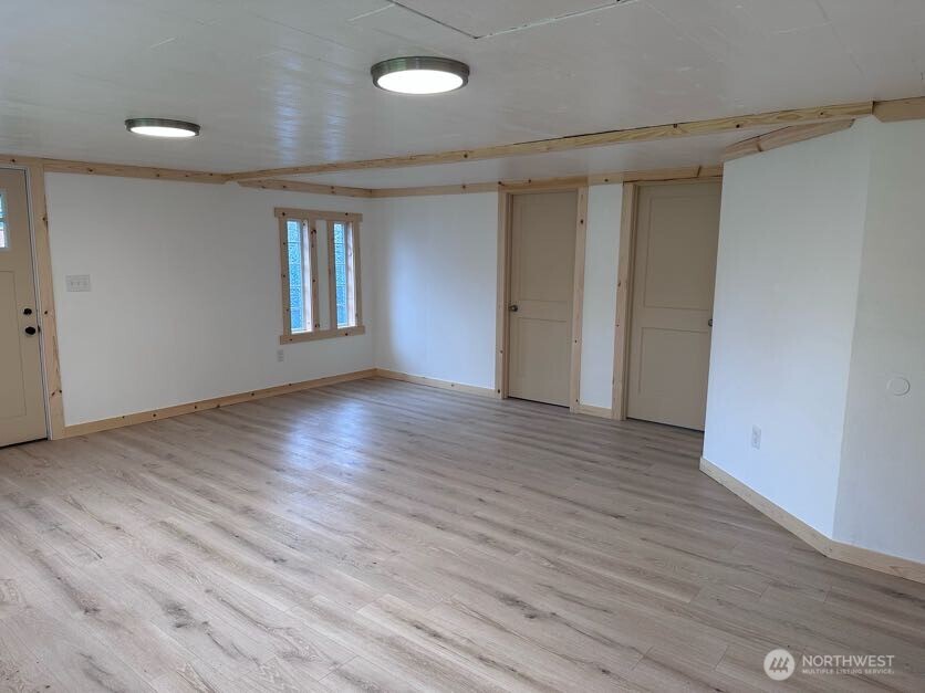 10341 184th Avenue Southwest Rochester, WA 98579 - Photo 28 of 36 a view of an empty room with wooden floor and a window
