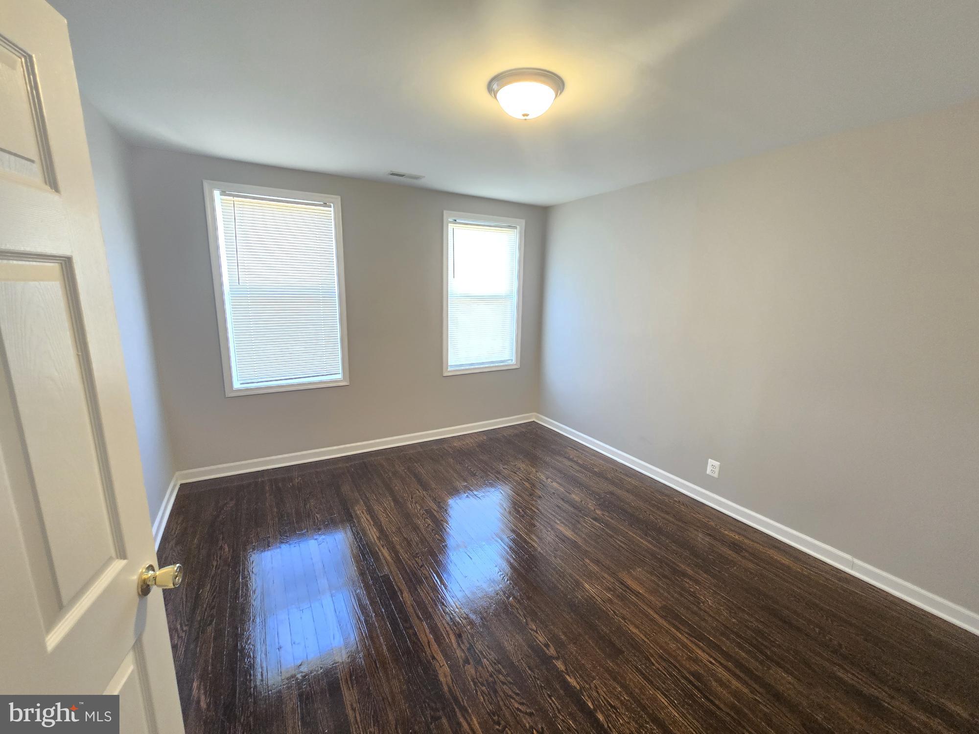 2805 Edison Highway Baltimore, MD 21213 - Photo 13 of 28 an empty room with wooden floor and windows