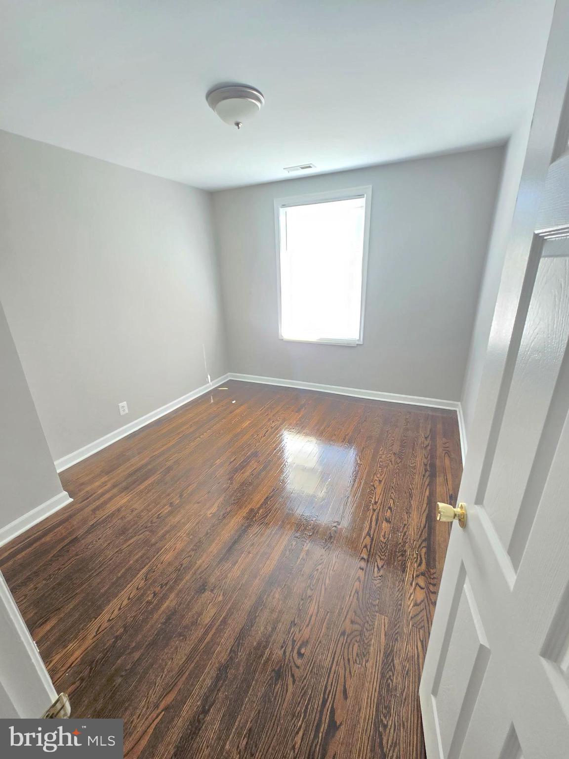 2805 Edison Highway Baltimore, MD 21213 - Photo 15 of 28 an empty room with wooden floor and windows