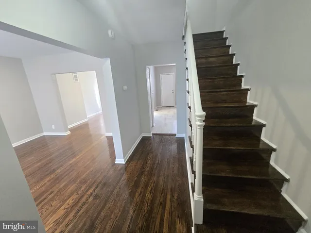 a view of a hallway with wooden floor and entryway