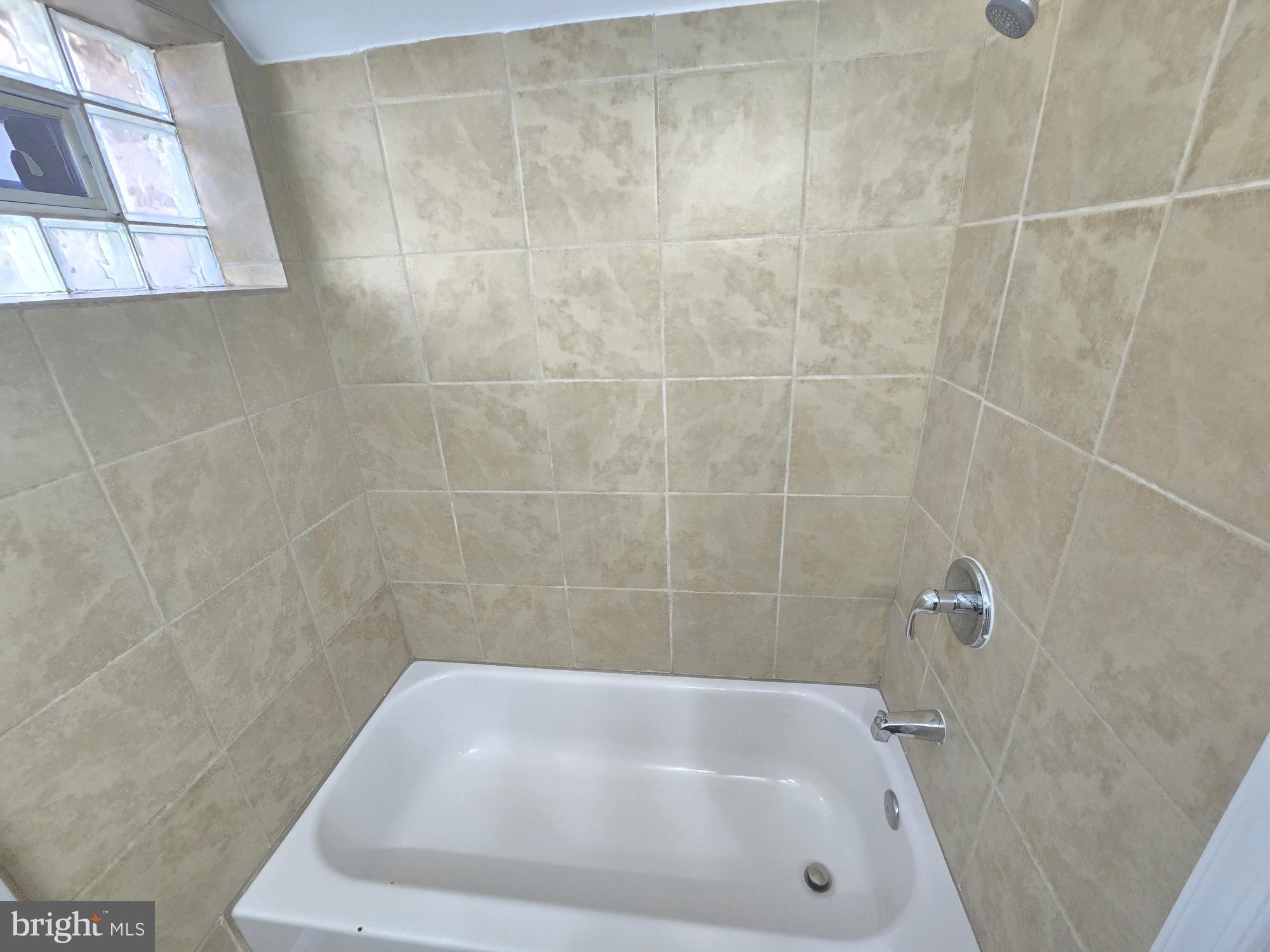 2805 Edison Highway Baltimore, MD 21213 - Photo 24 of 28 a bathroom with a white bath tub and a shower