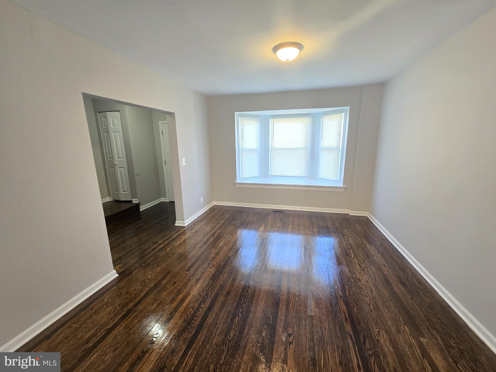 2805 Edison Highway Baltimore, MD 21213 - Photo 5 of 28 an empty room with wooden floor and windows