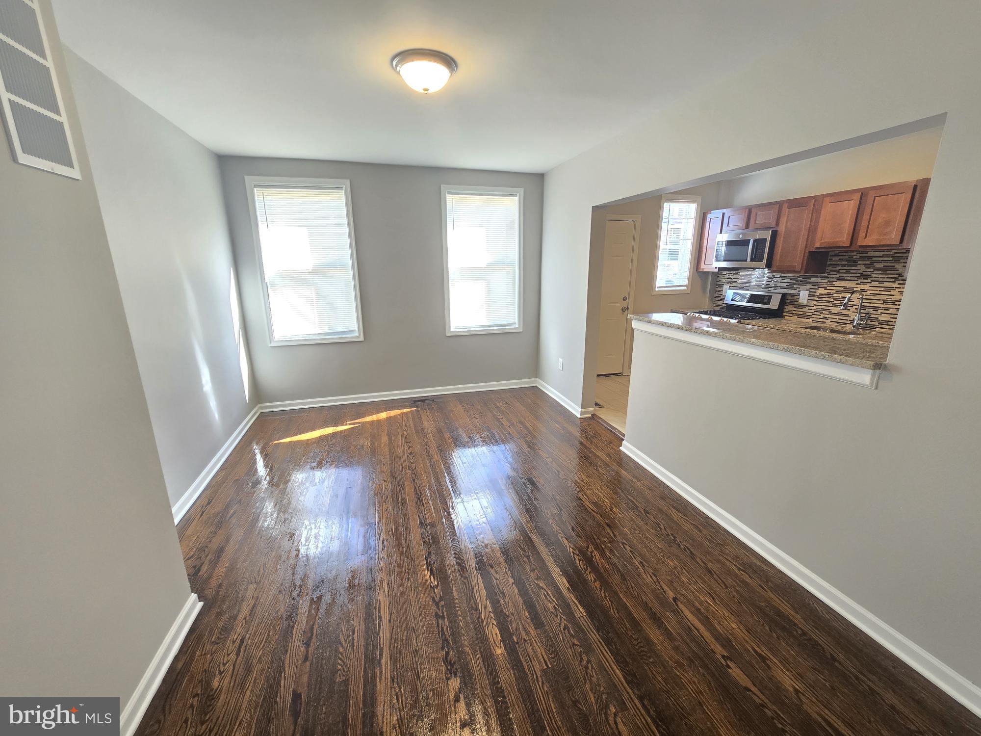 2805 Edison Highway Baltimore, MD 21213 - Photo 6 of 28 an empty room with wooden floor and windows