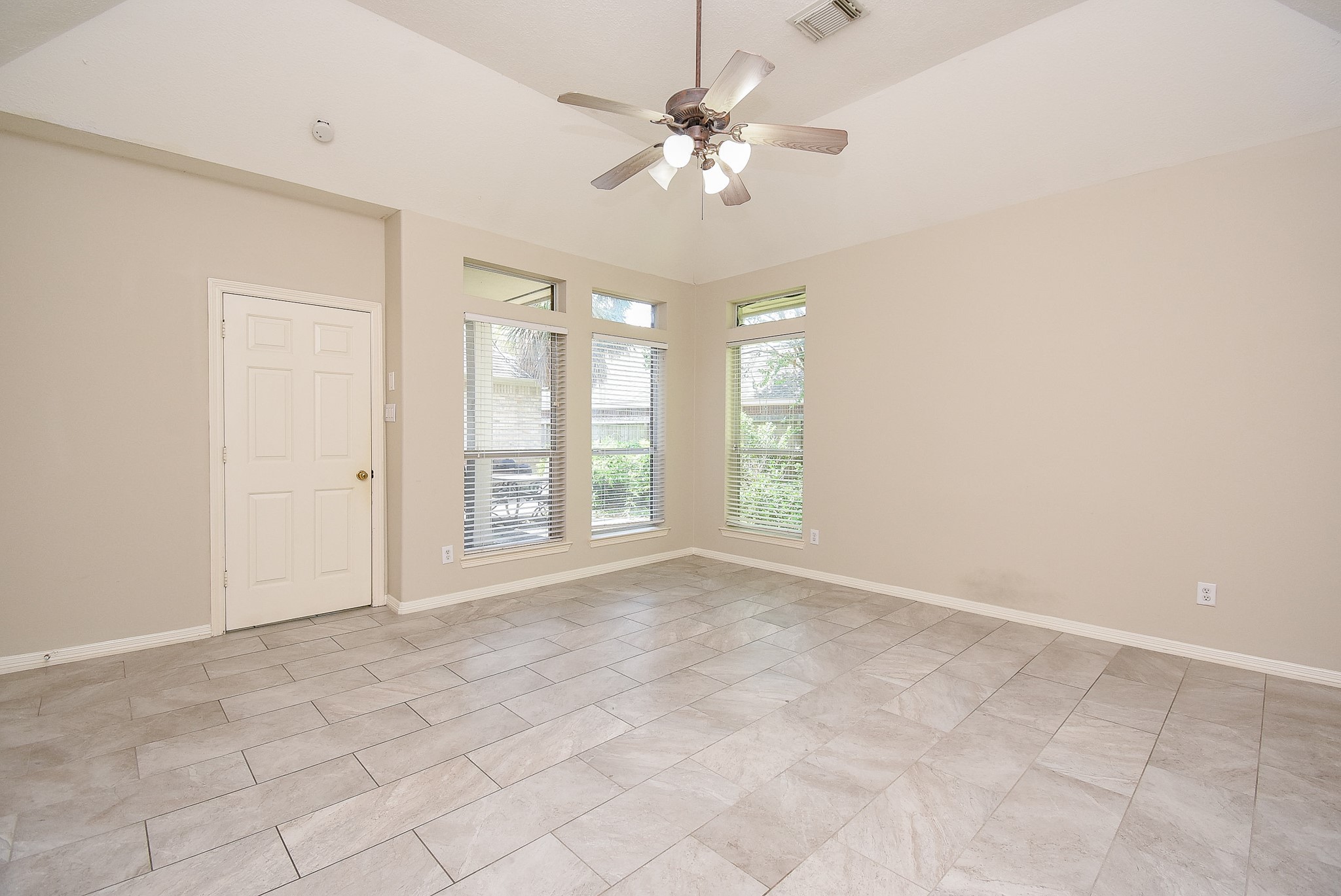 1714 Wellington Way Houston, TX 77055 - Photo 11 of 20 an empty room with chandelier fan and windows