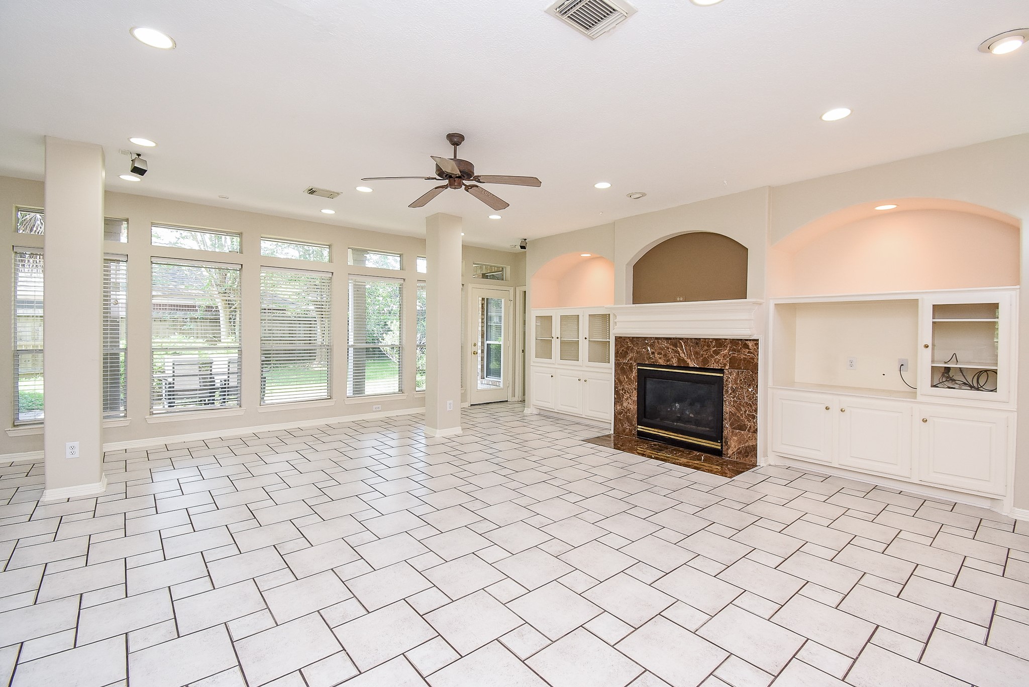 1714 Wellington Way Houston, TX 77055 - Photo 6 of 20 a view of a livingroom with a fireplace a ceiling fan and windows