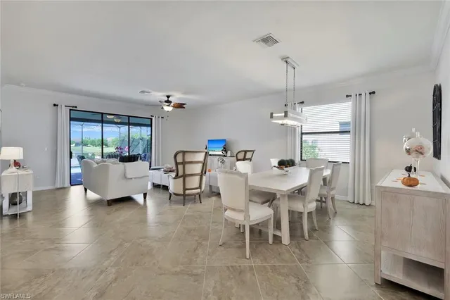 a dining room with furniture a chandelier and wooden floor