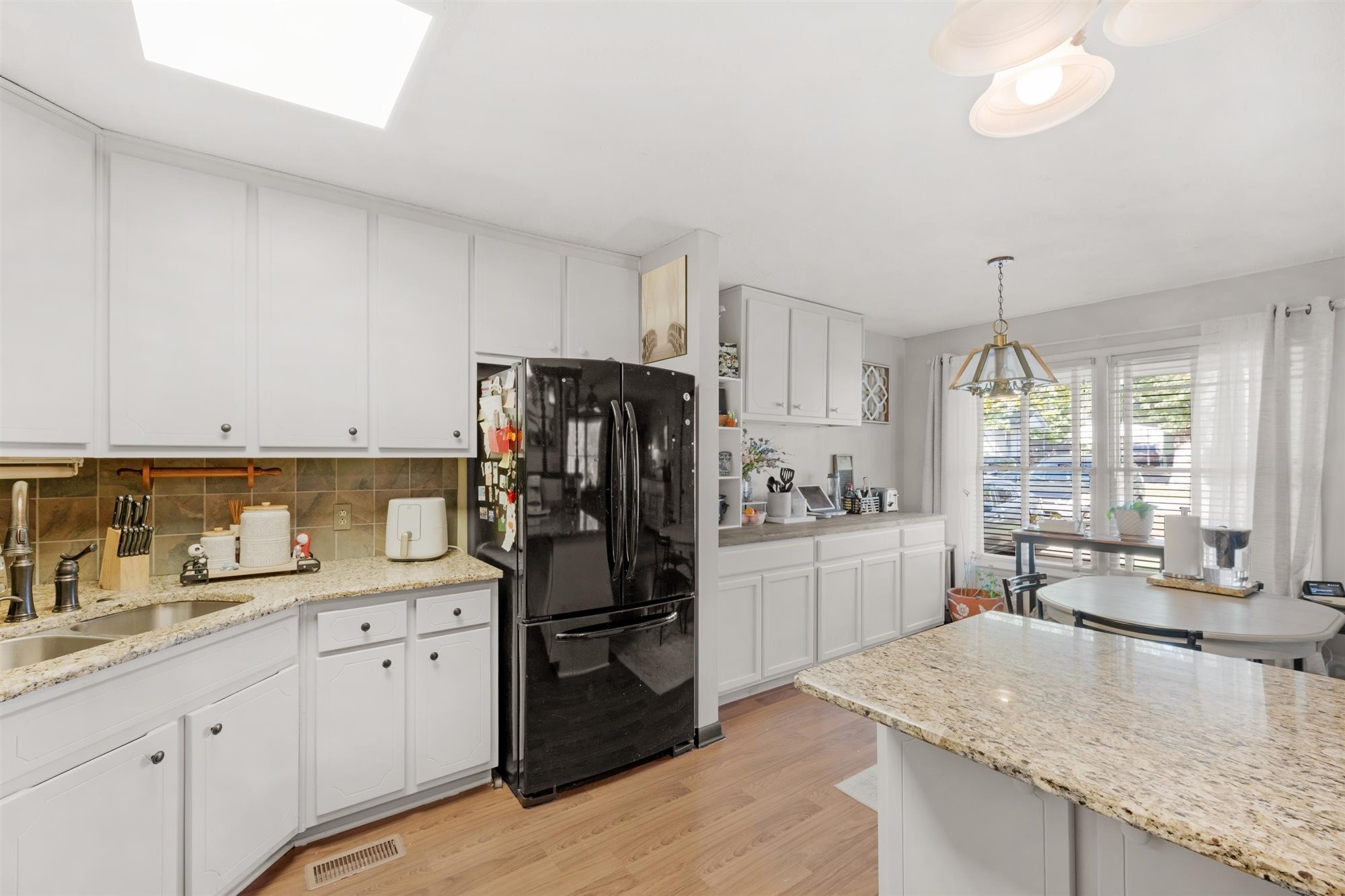 601 Courthouse View Street Lafayette, TN 37083 - Photo 23 of 25 a kitchen with a refrigerator a sink dishwasher a stove and white cabinets with wooden floor