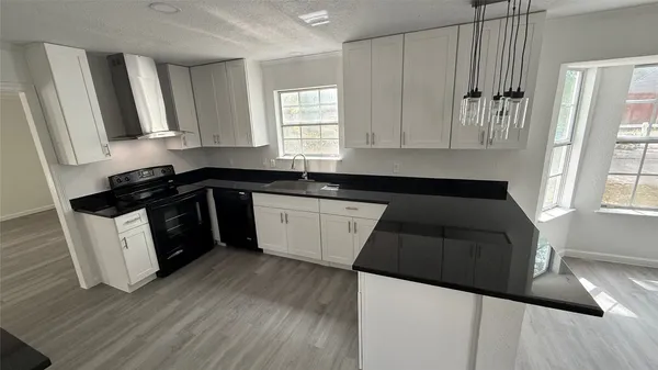 a white kitchen with sink and window