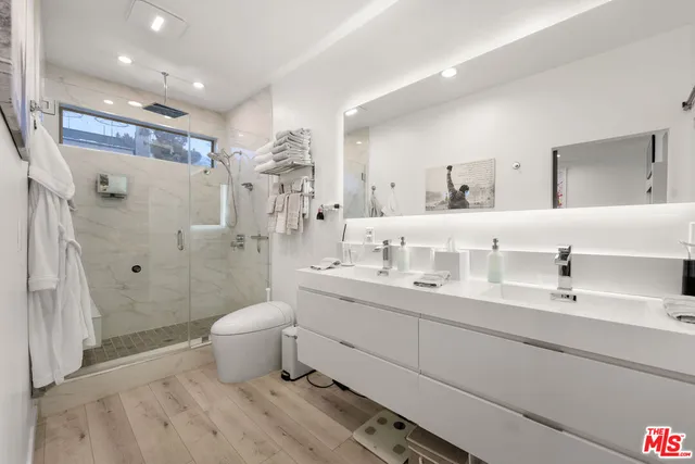 a bathroom with a double vanity sink toilet and shower