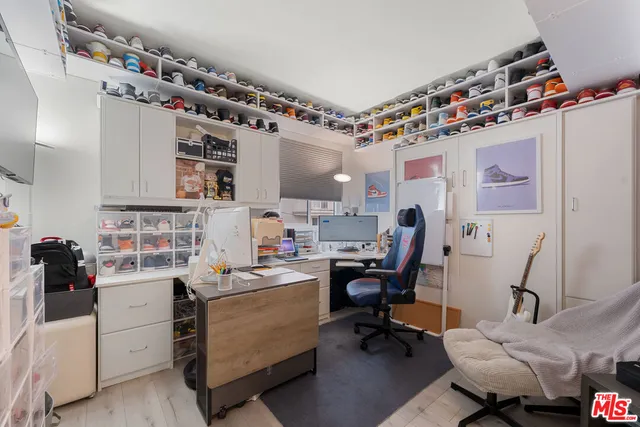 a view of a workspace with furniture and a window