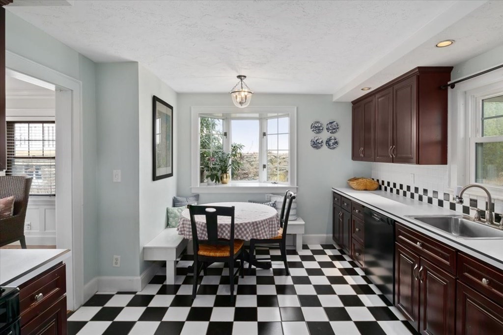 16 Sturges Road Boston, MA 02132 - Photo 5 of 34 a kitchen with a sink a stove a chair and a dining table