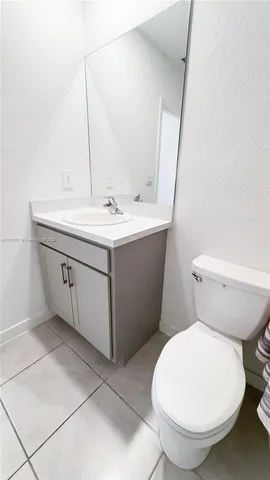 a large bathroom with mirror sink and refrigerator
