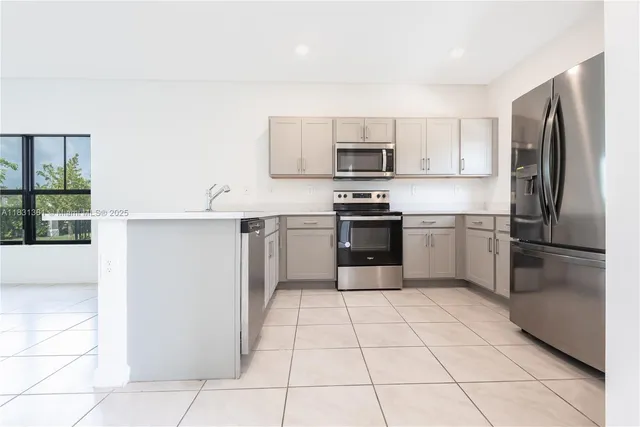 a kitchen with stainless steel appliances a refrigerator sink and microwave