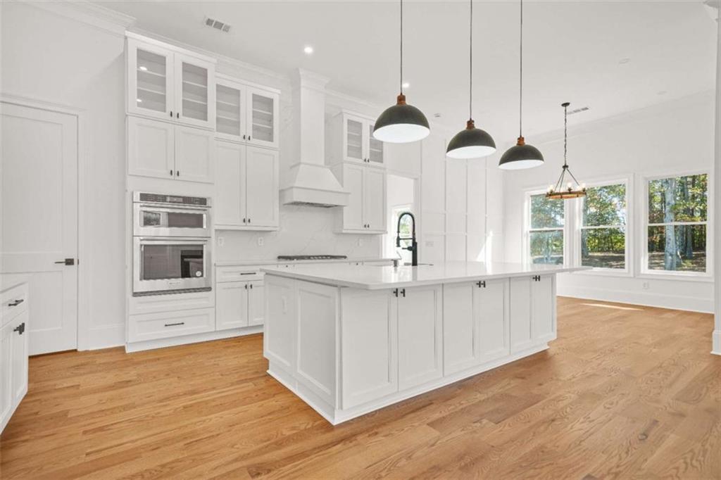 1525 Tapestry Ridge Southeast Lawrenceville, GA 30045 - Photo 16 of 49 a view of a kitchen with stainless steel appliances granite countertop a stove a sink a center island with wooden floor