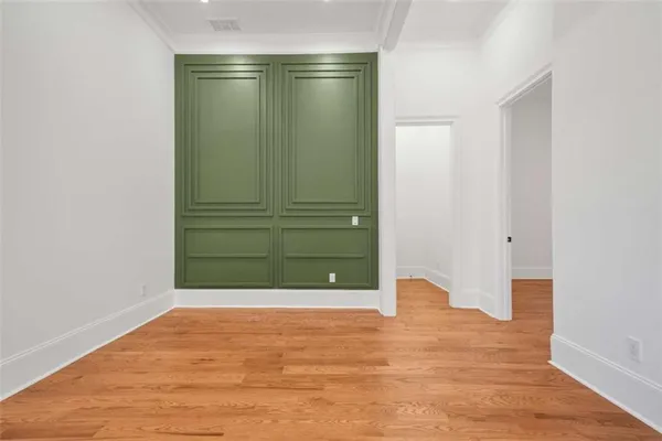 a large white kitchen with kitchen island a refrigerator a stove a sink and a dining table with wooden floor