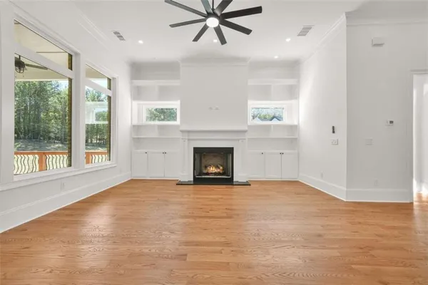 an empty room with wooden floor and window