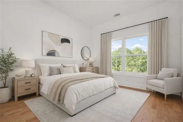 a spacious bedroom with a bed and a flat screen tv