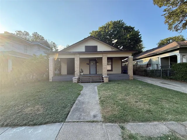 a view of a house with a yard and potted plants