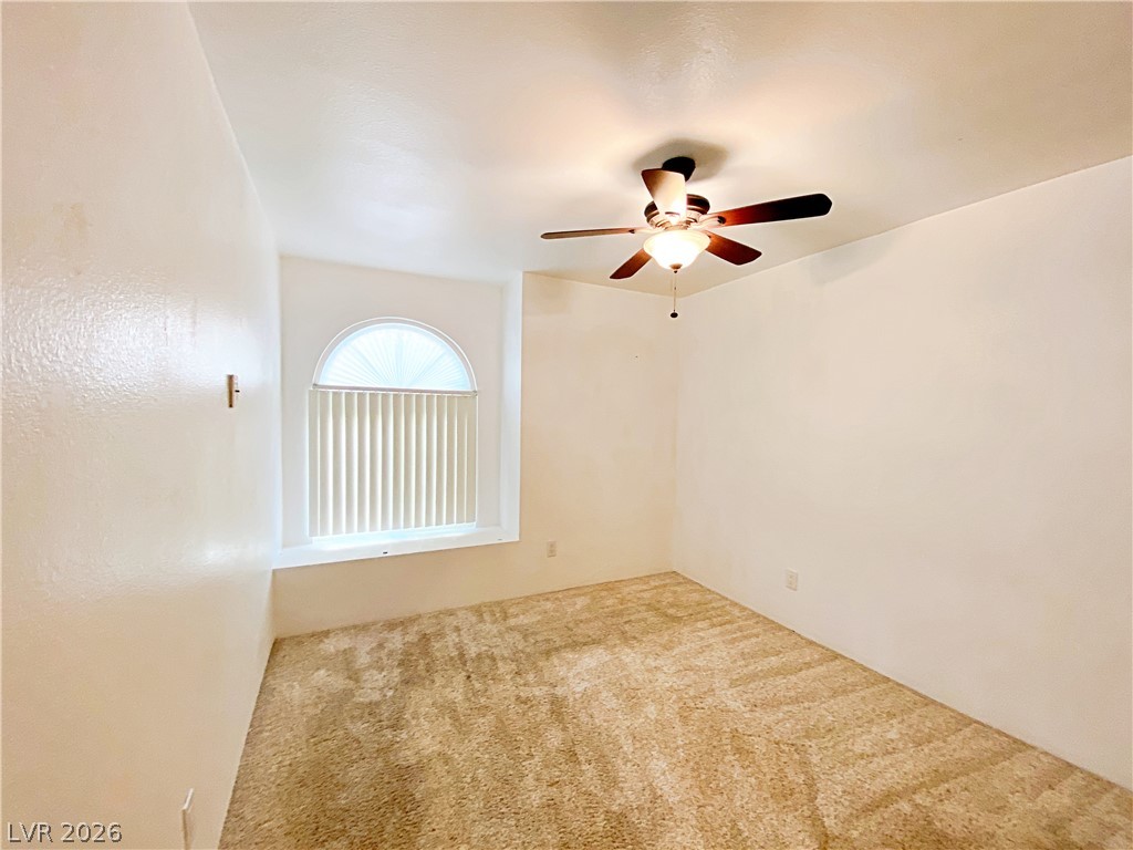 3145 East Flamingo Road, Unit 1128 Las Vegas, NV 89121 - Photo 9 of 19 A window-filled room with a vaulted ceiling and functional ceiling fan.