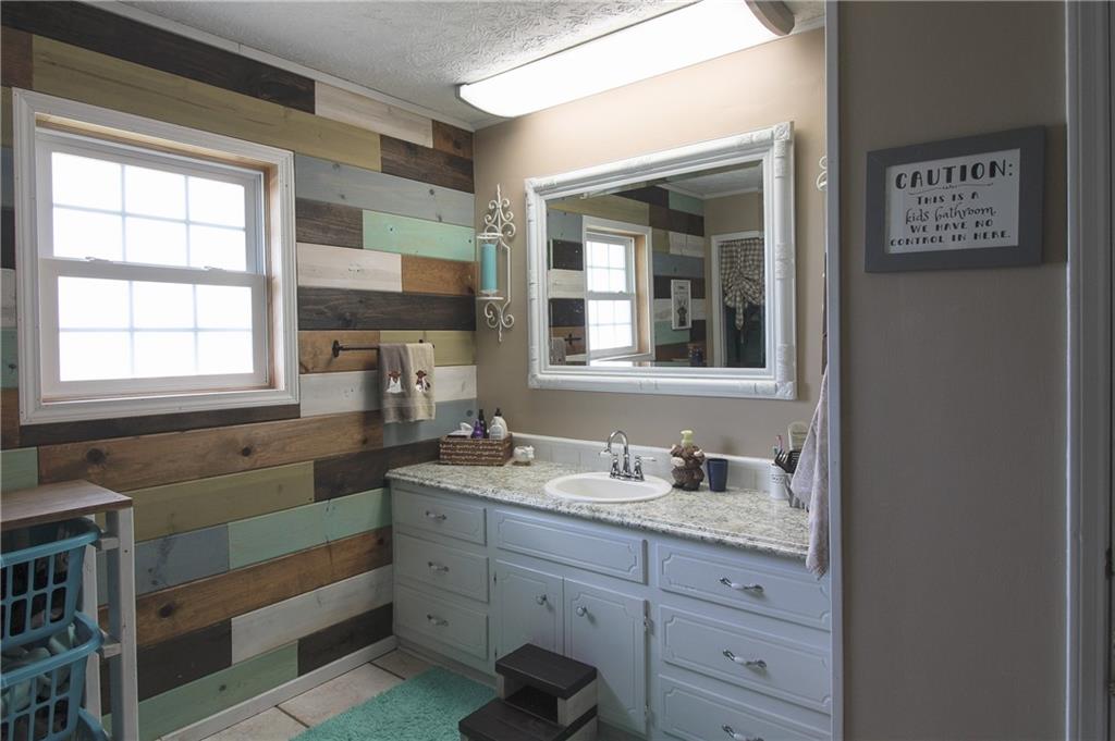 249 Cooper Road Southeast Calhoun, GA 30701 - Photo 28 of 62 a bathroom with a granite countertop sink mirror and window