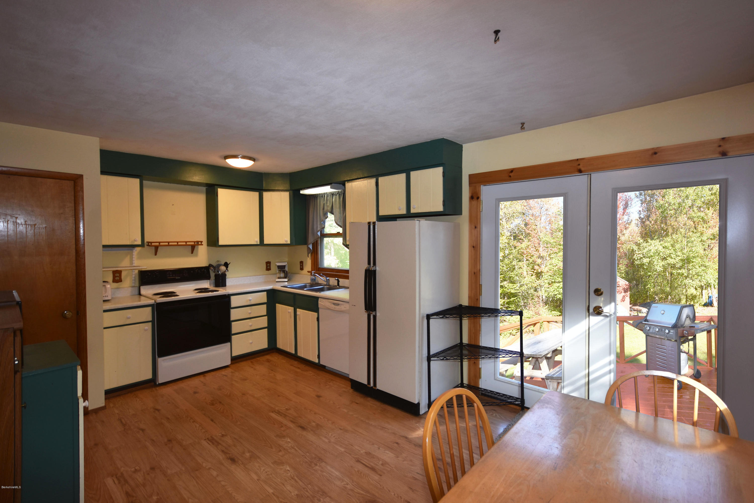 239 East Windsor Road Peru, MA 01235 - Photo 10 of 38 a kitchen with stainless steel appliances granite countertop a refrigerator a stove a sink a dining table and chairs with wooden floor