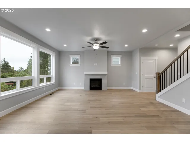 a view of a livingroom with a ceiling fan fireplace and a window