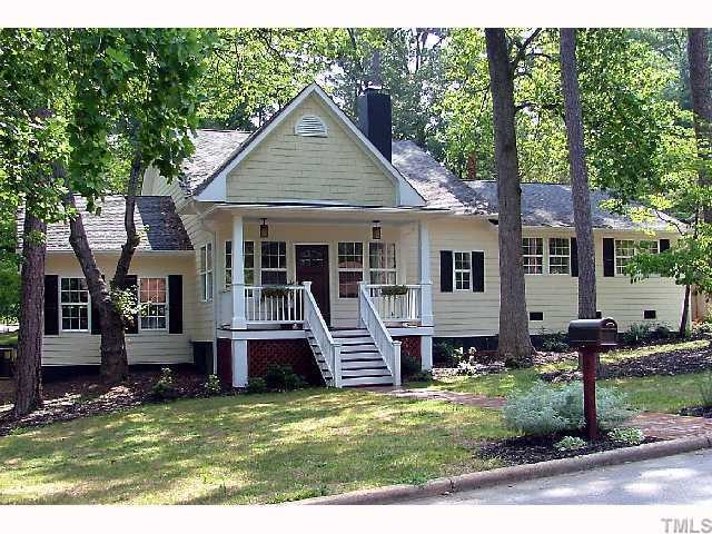 Beautiful front lawn with rocking chair porch and beautiful mature trees.