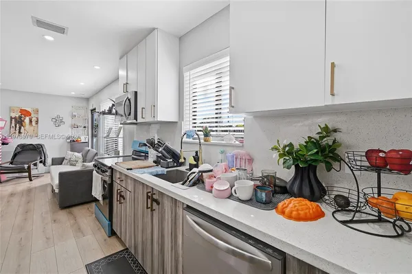 a kitchen with a sink potted plant and a stove