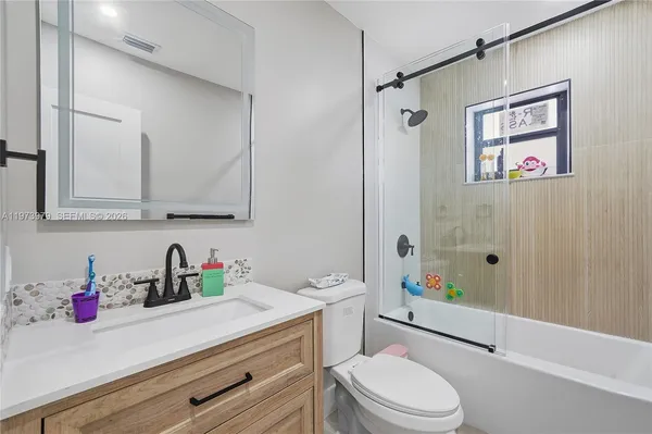 a bathroom with a sink toilet a mirror and shower