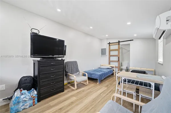 a bedroom with furniture and a flat screen tv