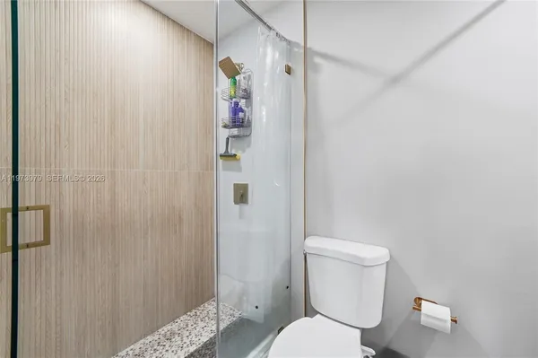 a white toilet sitting next to a shower curtain