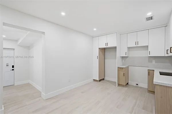 a kitchen with white cabinets and sink