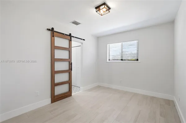 an empty room with windows and closet