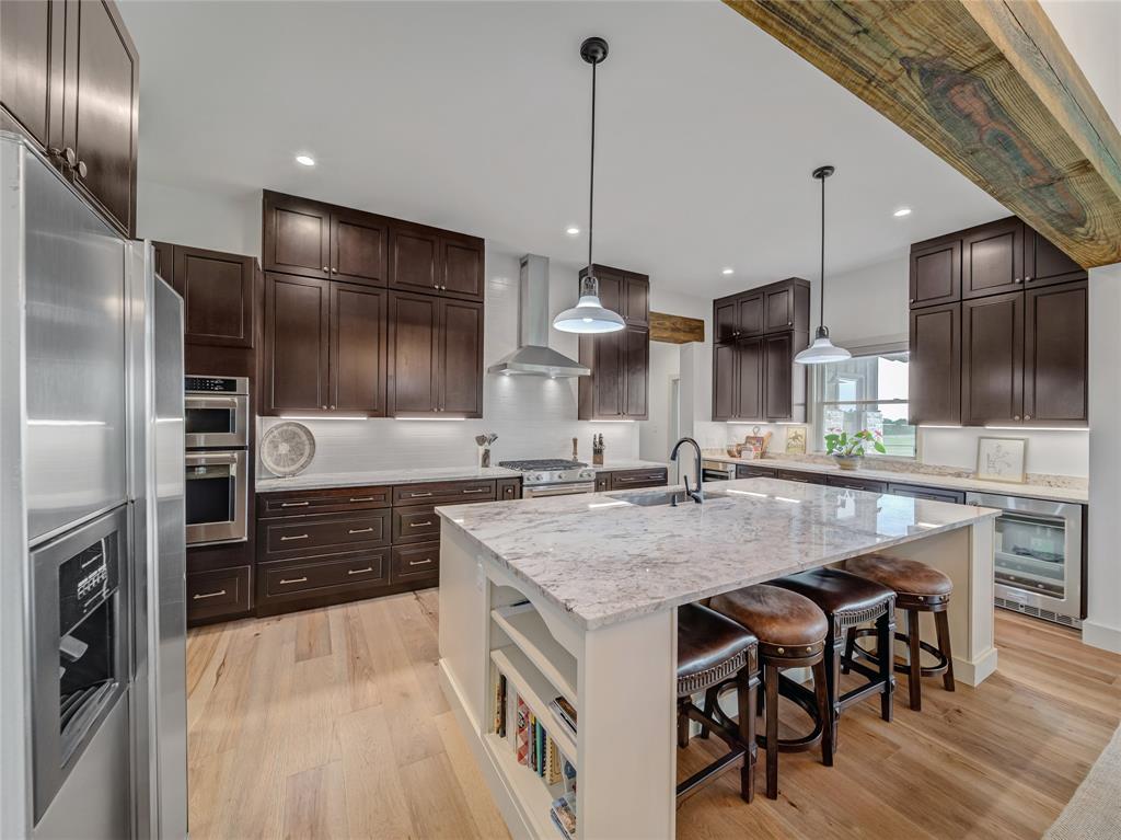6362 Belz Road Sanger, TX 76266 - Photo 11 of 40 a kitchen with a table chairs refrigerator and microwave