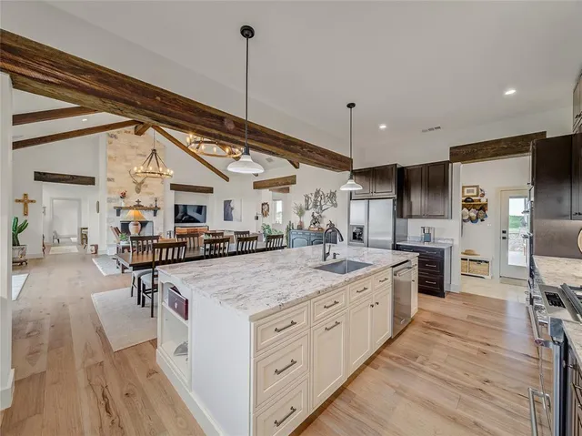 a large kitchen with stainless steel appliances kitchen island granite countertop a large island in the center