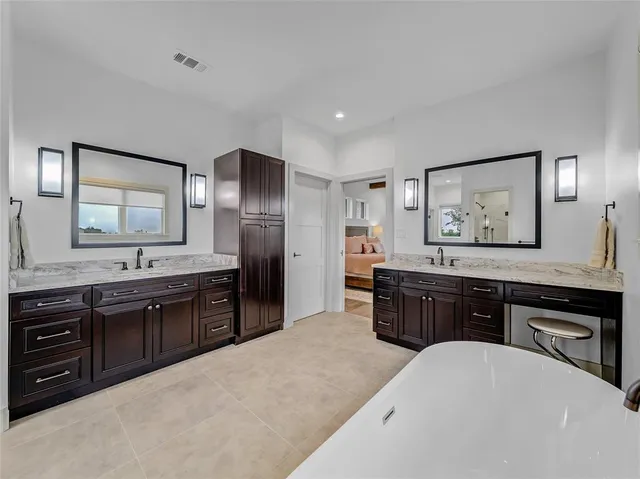 a spacious bathroom with a granite countertop double vanity sink and a mirror