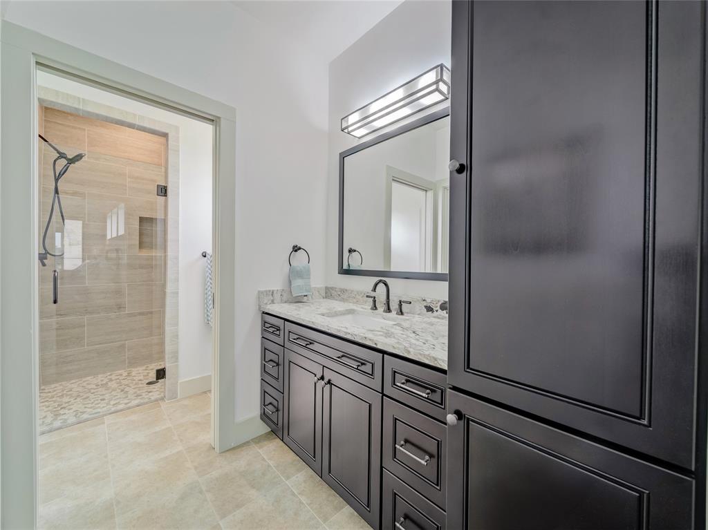 6362 Belz Road Sanger, TX 76266 - Photo 22 of 40 a bathroom with a granite countertop sink a mirror and a shower