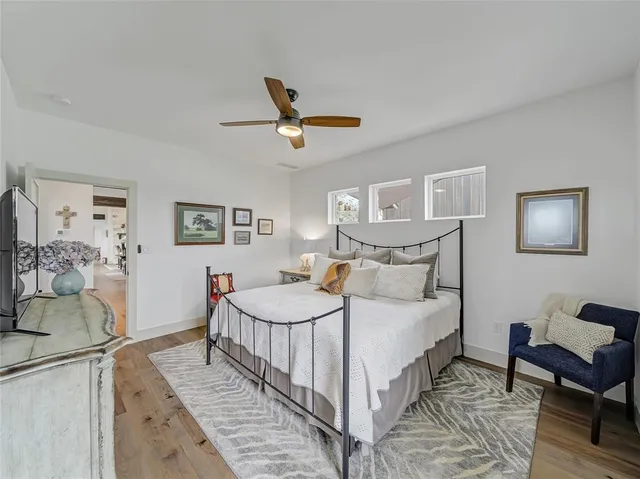 a bedroom with a bed a couch and paintings on the wall