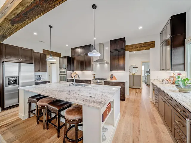 a kitchen with stainless steel appliances granite countertop a kitchen island a stove and a sink