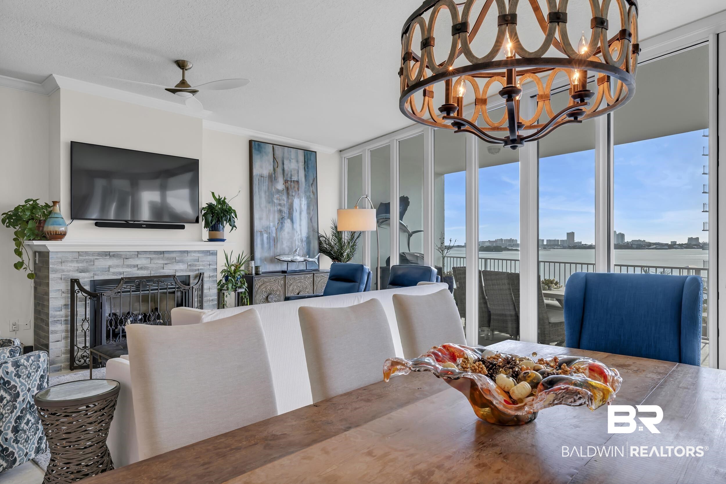 28250 Canal Road, Unit 307 Orange Beach, AL 36561 - Photo 25 of 56 Dining room featuring ornamental molding, a brick fireplace, a ceiling fan, a textured ceiling, and hanging lights