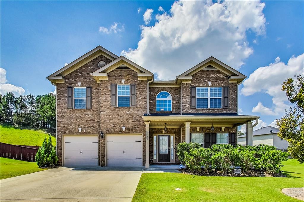 a front view of a house with a yard and garage