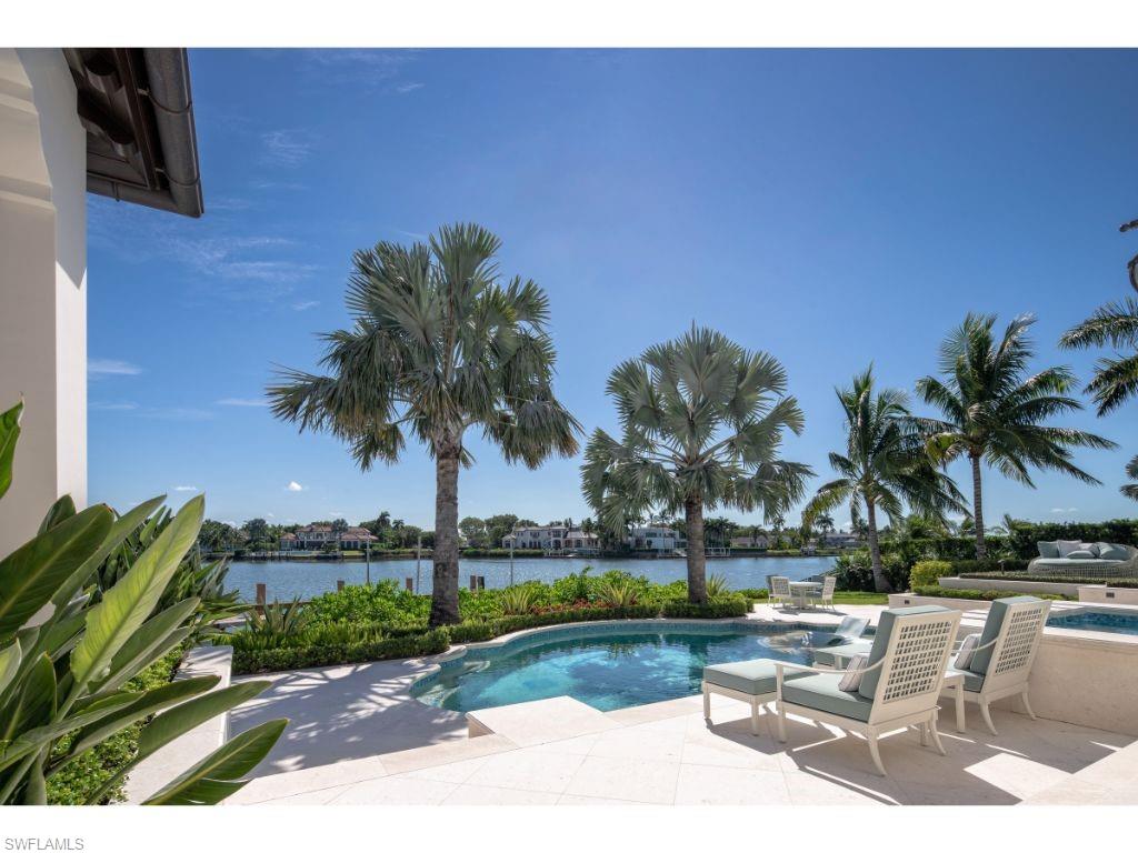 3401 Rum Row Naples, FL 34102 - Photo 21 of 22 a view of a swimming pool with a table and chairs