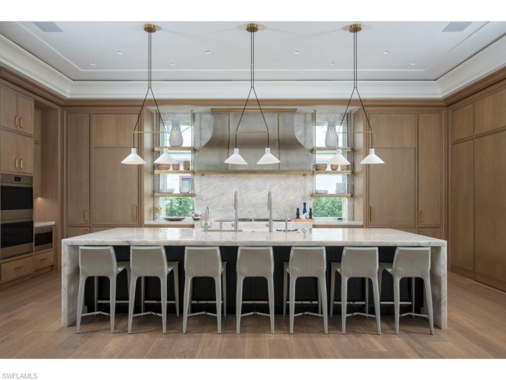 3401 Rum Row Naples, FL 34102 - Photo 6 of 22 a kitchen with lots of wooden furniture dining table and chairs