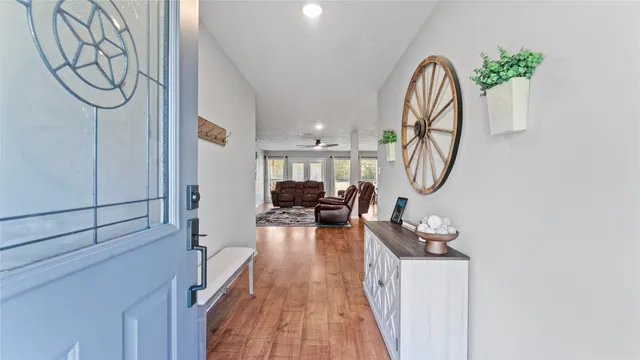 a large kitchen with stainless steel appliances granite countertop a refrigerator a sink dishwasher a stove and white cabinets with wooden floor