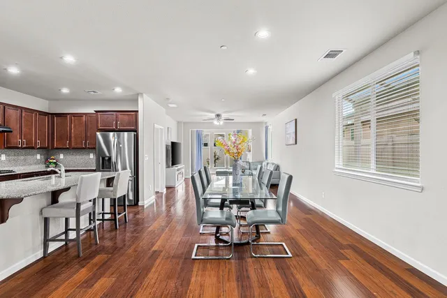 an empty room with wooden floor and a ceiling fan